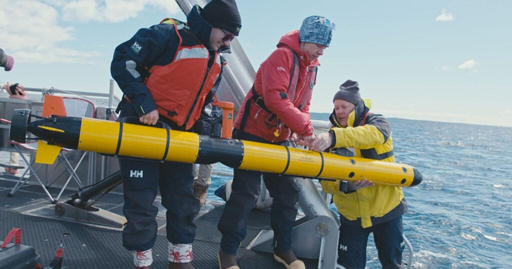 Ella Wawrzynek, Madeline Miller, and David Whelihan deploy their sensor-equipped AUV from the University of New Hampshire's Gulf Surveyor into the Atlantic Ocean.
