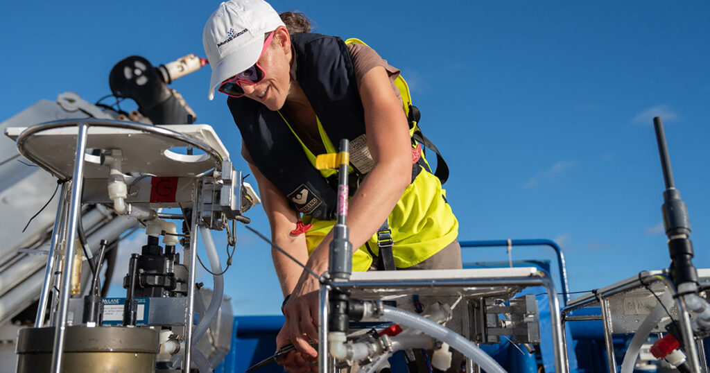 While on the aft deck of Falkor (too), Hilary Close (Scientist, Ocean Sciences at the Rosenstiel School of Marine, Atmospheric, and Earth Science at the University of Miami) examines a sensor, searching for chemical traces that help explain the transformation and transportation of carbon and nitrogen through different depths of the ocean.