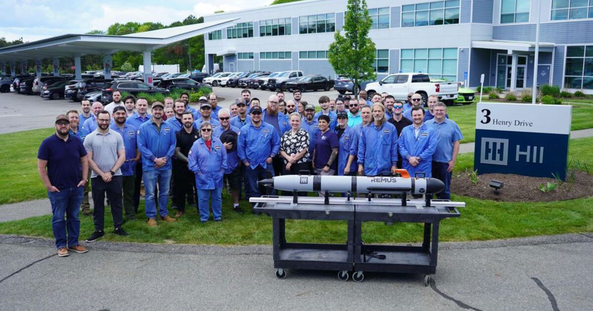 Employees of HII's Unmanned Systems group pose outside HII's facility in Pocasset, Massachusetts, with the first REMUS 130 unmanned underwater vehicle delivered to a US ally. The delivery marks a major milestone for the next generation of the world's most widely deployed autonomous underwater vehicle.