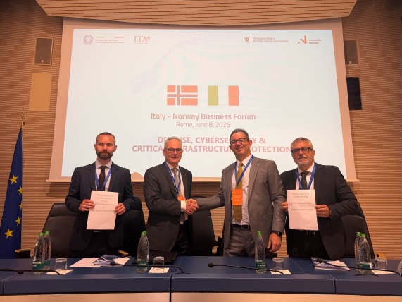 Espen Henriksen, SVP Uncrewed Platforms, KONGSBERG, and Drass CEO Sergio Cappelletti formalize the agreement with a handshake flanked by Sigurd Aksnes Fjerdingen (left), VP Products, Uncrewed Platforms at KONGSBERG, and Marco Bellomo, Technical Director at DRASS. 
