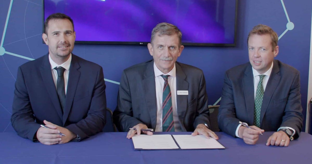 Representatives from ACUA Ocean Technologies, Babcock, and Frankenburg with signed Memorandum of Understanding, in front of a blue Babcock branded background