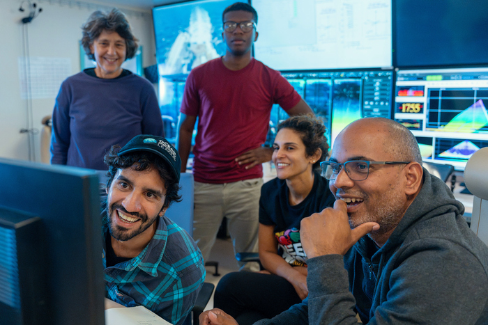 (L-R) Dr. Juliano Palacios Abrantes, Dr. Anna Metaxas, Ryan Manette, Kyle Foster, and Dr. Diva Amon celebrate the first successful deployment and recovery of DORIS, the Deep Ocean Research and Imaging System. DORIS, developed by the Ocean Discovery League and Blue Robotics, is an experimental, cutting-edge, and low-cost deep-sea camera that aims to revolutionize deep ocean exploration with affordable technology designed for global accessibility. (Image credit: Mónika Naranjo González, Schmidt Ocean Institute)