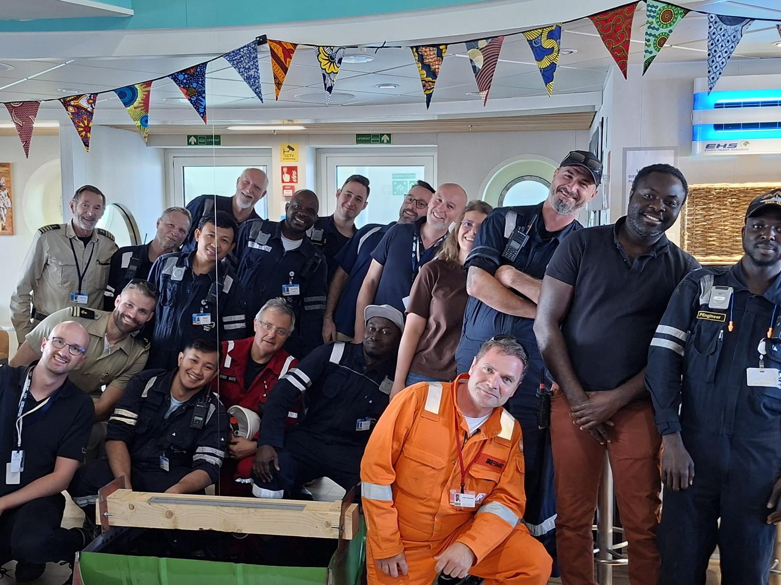 The Tymor Marine team with crew members aboard the Global Mercy following completion of the lightweight survey and inclining test. Pictured are Principal Naval Architect Niall MacLennan (front row, seated, left) and Managing Director Kevin Moran (standing, eighth from left). (Image credit: Tymore Marine)