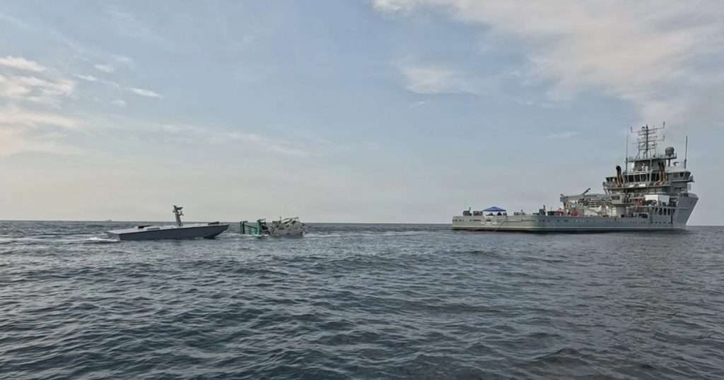 The T38 unmanned surface vessel, left, approaches a towable capture and connection device, center, towed by USNS Vindicator (TSV 5), right, during an Aug. 11 refueling demonstration off Joint Expeditionary Base Little Creek-Fort Story, Virginia. Naval Air Warfare Center Weapons Division’s Blue Water Instrumentation program led the demonstration, part of an effort to keep unmanned vessels on station longer during long-range weapons testing. (Image credit: Naval Air Warfare Center Weapons Division)
