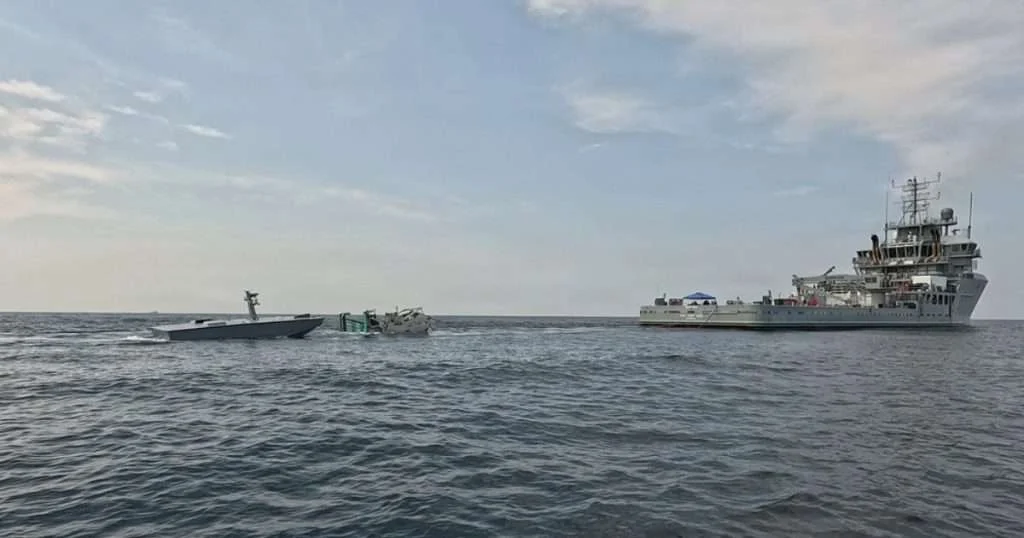 The T38 unmanned surface vessel, left, approaches a towable capture and connection device, center, towed by USNS Vindicator (TSV 5), right, during an Aug. 11 refueling demonstration off Joint Expeditionary Base Little Creek-Fort Story, Virginia. Naval Air Warfare Center Weapons Division’s Blue Water Instrumentation program led the demonstration, part of an effort to keep unmanned vessels on station longer during long-range weapons testing. (Image credit: Naval Air Warfare Center Weapons Division)