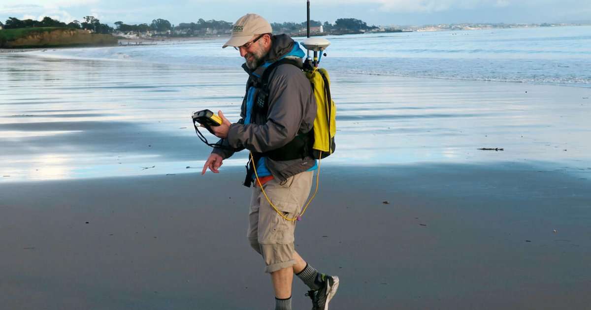 USGS oceanographer Dan Hoover uses a GPS-equipped backpack to measure sand elevations near the mouth of the San Lorenzo River in Santa Cruz, California, January 12, 2017. Surveys like this make long-term studies of coastal change possible. (Image credit: USGS)