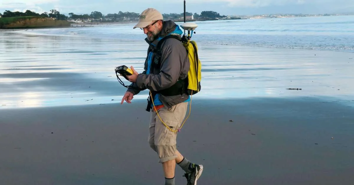 USGS oceanographer Dan Hoover uses a GPS-equipped backpack to measure sand elevations near the mouth of the San Lorenzo River in Santa Cruz, California, January 12, 2017. Surveys like this make long-term studies of coastal change possible. (Image credit: USGS)